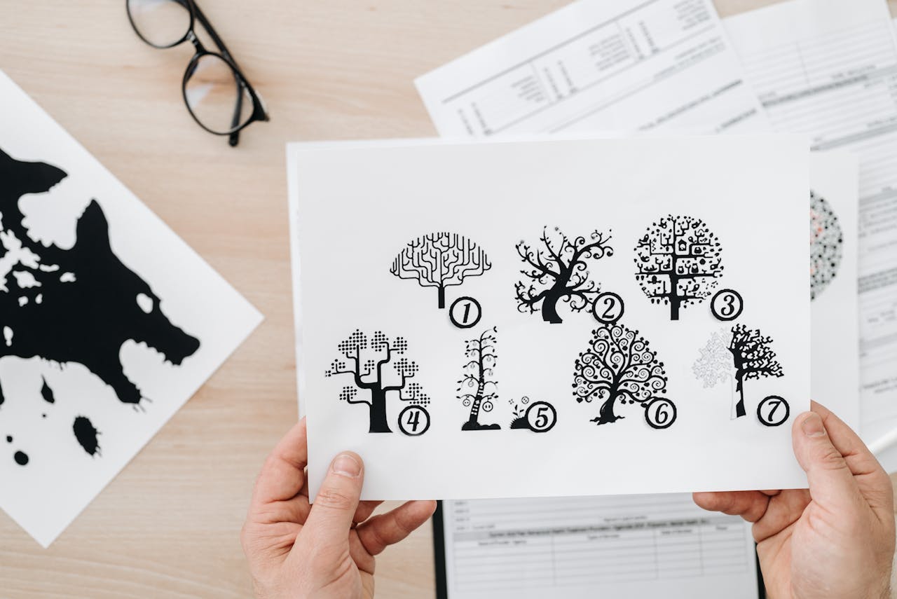 about-us Close-up showing hands holding paper with tree test illustration for psychological assessment.